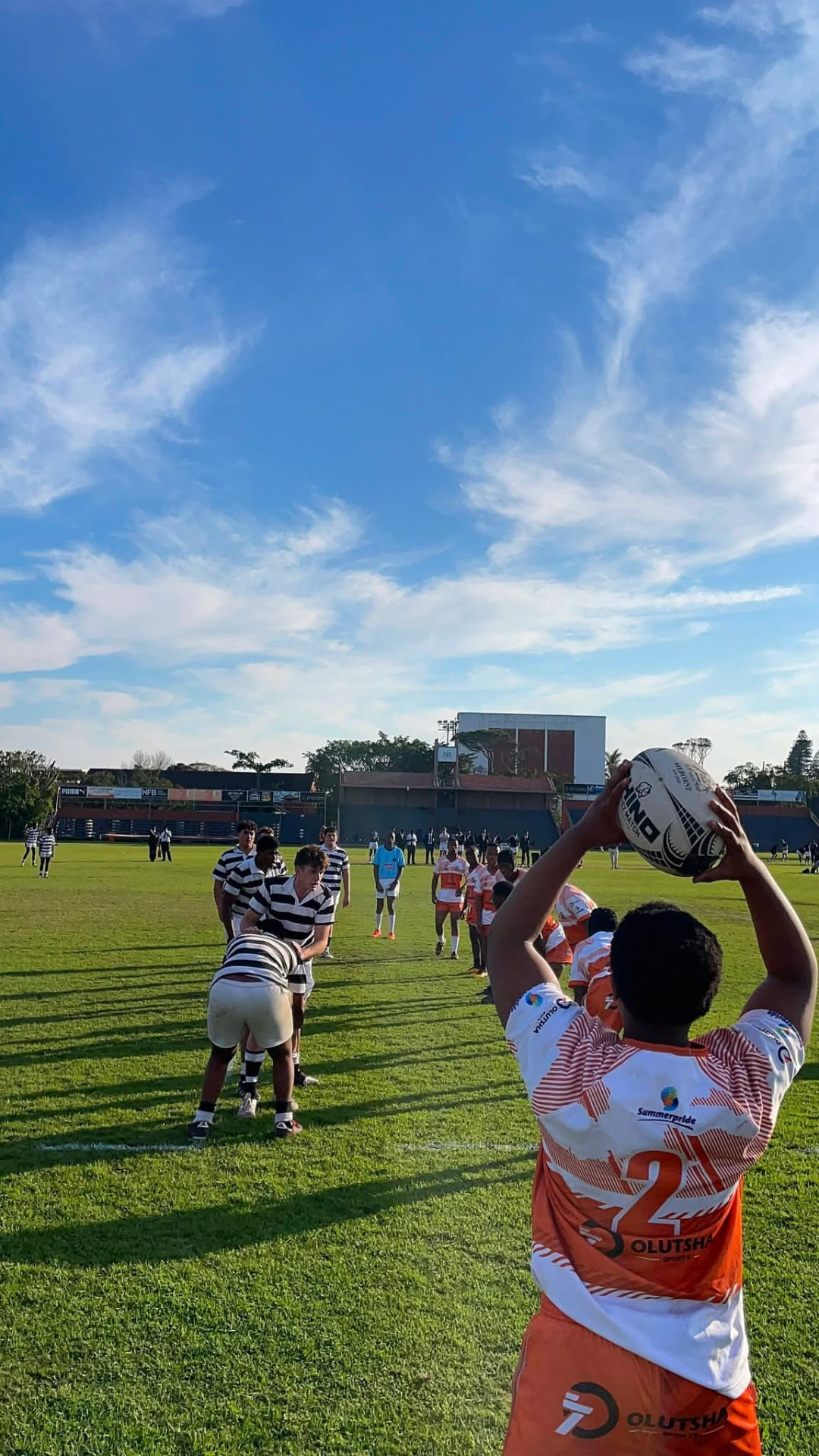 Olutsha Academy hooker throwing into a lineout under a blue sky