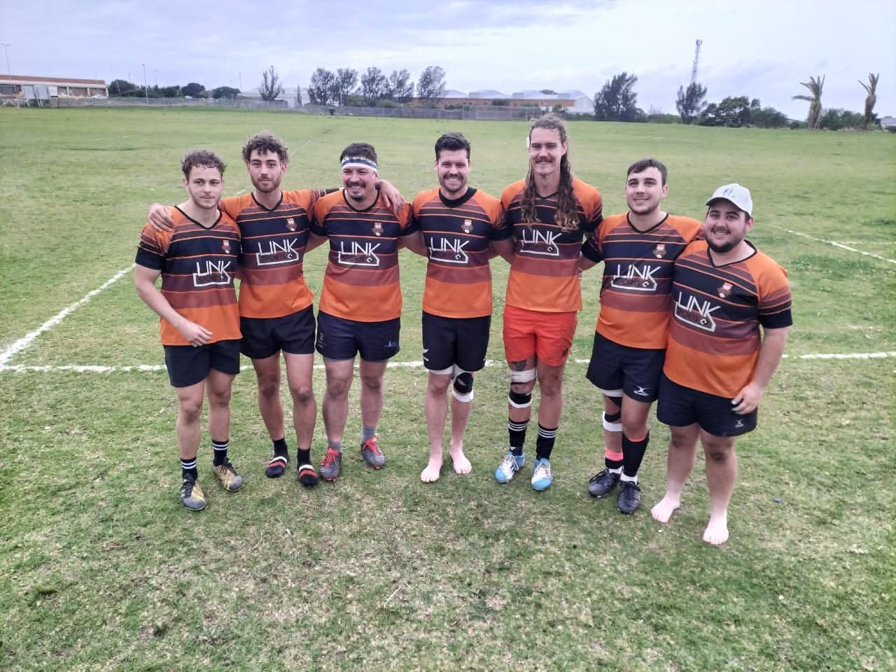Olutsha Wolves team-mates arm in arm on the field after a match