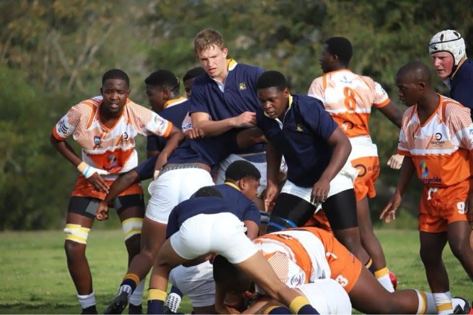 Academy forwards competing at a ruck against a navy-jerseyed school side